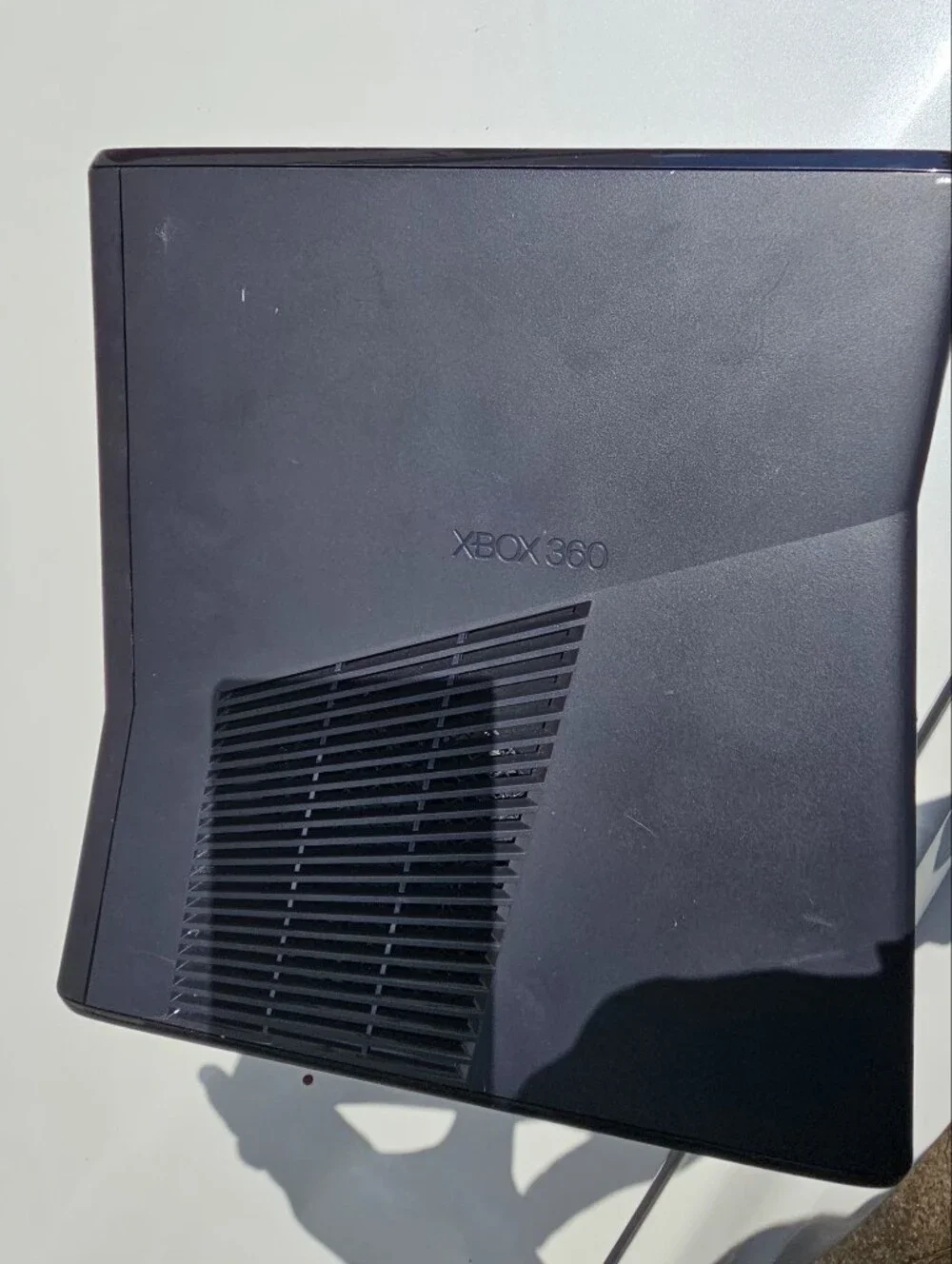 Microsoft Xbox 360 S (Slim) console, featuring a sleek black